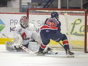 Moose Jaw Warriors goalie Carl Tetachuk slides across the net as the Regina Pats' Braxton Whitehead tries to get his stick on the loose puck during Wedneday's game at the Brandt Centre. The Pats won 4-3 to extend their winning streak to three games.