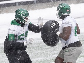 Saskatchewan Roughriders offensive lineman Josiah St. John, left, participates in a drill during a practice earlier this week.