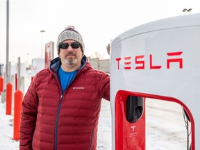 Tesla owner Russ Lepage stands near the new Tesla charging stations in Stonebridge, Nov. 18, 2021.