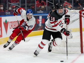 The Regina Pats' Connor Bedard, right, carries the puck for Canada in Sunday night's world junior hockey championship game against Czechia.