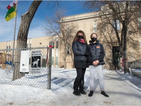 Cristina Ruiu, left, and her daughter Victoria Bateman stand in front of Holy Rosary School in Regina, Saskatchewan on Feb. 2, 2021.