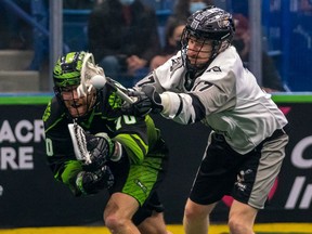 Saskatchewan Rush defender Holden Garlent and Calgary Roughnecks forward Curtis Dickson battle for possession of the ball during the second quarter of National Lacrosse League action at Sasktel Centre in Saskatoon, on Saturday, Dec. 11, 2021.