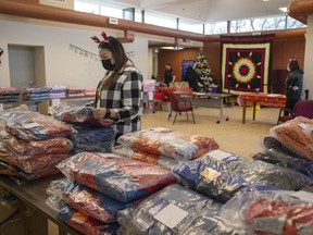 The Circle Project is conducting Operation Warm, distributing warm coats and wear, on Thursday, December 16, 2021 in Regina. Larissa Anderson, director of children services, helps gets jackets to be distributed.