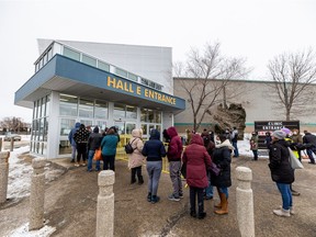People gather outside of Prairieland Park for COVID-19 vaccines. Photo taken in Saskatoon, SK on Monday, December 20, 2021.