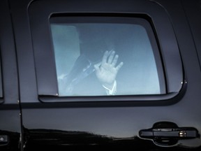 U.S. President Donald Trump waves from the presidential motorcade while arriving at Walter Reed National Military Medical Center in Bethesda, Maryland on Friday, Oct. 2, 2020, to be treated for Covid-19.