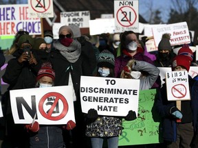 Children stand at the front of a rally against Quebec's Bill 21 on Dec. 14, 2021 in Chelsea, Que. The bill prohibits some public sector workers from wearing religious symbols at work, after a teacher was removed from her position because she wears a hijab.