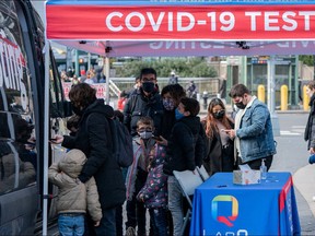 People queue at a popup COVID-19 testing site in New York, U.S., December 3, 2021. REUTERS/Jeenah Moon