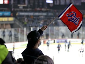 A masked Regina Pats fan cheers on his team during Wednesday's game against the Winnipeg Ice at the Brandt Centre. Earlier in the day, the remainder of the 2022 world junior hockey championship was cancelled due to the surging Omicron variant.