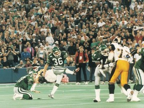 Dave Ridgway, 36, hits the Saskatchewan Roughriders' winning basket in the 1989 Gray Cup game against the Hamilton Tiger-Cats.  Glen Suitor, 27, is the incumbent.  Tim McCray, 14, is at right.  Bill Dubecky / Royal Studios.