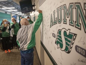 Jerry (Pee Wee) Wasnik signs the Saskatchewan Roughriders' alumni wall at Mosaic Stadium on Wednesday — his 87th birthday.