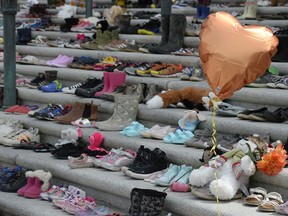 Children's shoes in a display to represent children who died while in Canada's residential school program are seen on the steps of the Saskatchewan Legislative Building in Regina, Saskatchewan on May 31, 2021.