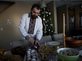 Reverend Father Volodymyr Feskiv serves food during Holy Supper on Ukrainian Christmas Eve on Thursday, January 6, 2022 in Regina.