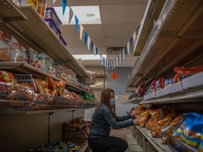 Co-owner of G and J Filipino Food Store Glenda Negulo stocks the shelves at her store on Friday, January 7, 2022 in Regina. KAYLE NEIS / Regina Leader-Post