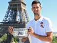 Novak Djokovic poses on June 14, 2021, in front of The Eiffel Tower in Paris, one day after winning the Roland Garros 2021 French Open tennis tournament.
