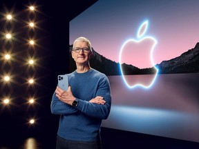 Apple CEO Tim Cook holds the iPhone 13 Pro Max and Apple Watch Series 7 during a special event at Apple Park in Cupertino, Calif., broadcast Sept. 14, 2021.