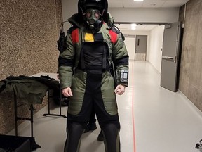 A Regina Police Service explosives and chemical disposal expert has his bomb suit checked before helping remove and dispose of old chemicals found in University of Regina science laboratories on Jan. 7, 2022.