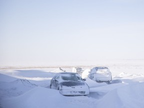 Parked vehicles are covered in snow on Mapleford Boulevard in Regina after a blizzard hit Saskatchewan the previous night on Tuesday.