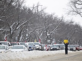 A protester holds a sign at oncoming vehicles alongside Albert Street and 20th Avenue on Saturday, February 5, 2022 in Regina. KAYLE NEIS / Regina Leader-Post