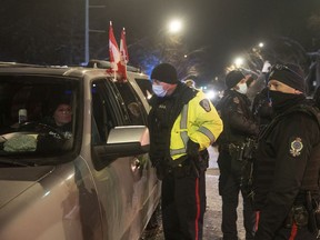 Organizer Tamara Lavoie speaks to the police from her parked car on the corner of Albert Street and 20th Avenue as the police began removing vehicles parked in protest to vaccine mandates on Sunday, February 6, 2022 in Regina. KAYLE NEIS / Regina Leader-Post