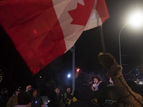 Les manifestants chantent l'hymne national au coin de la rue Albert et de la 20e Avenue lors d'un affrontement avec la police de Regina tard dans la soirée du 6 février 2022 à Regina. KAYLE NEIS / Poste de chef de Regina