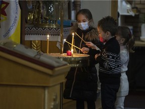 Ivanna Shyan, Daniella Nikolaeva and David Nikolaev light candles during a prayer ceremony for Ukraine held at the Descent of the Holy Spirit, Ukrainian Orthodox Church-Sobor on Thursday, February 24, 2022 in Regina.