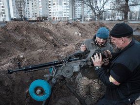 Members of the territorial defense battalion set up a machine gun on February 25, 2022 in Kyiv, Ukraine.