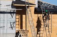 A construction worker climbs a ladder while working at a residential property in the east end of Regina.