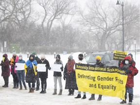 Attendees hold signs during a demonstration "to advance women's human rights in Regina and worldwide. The rally was held outside the Saskatchewan Legislative Building.