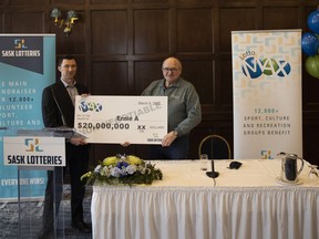 Ernie Anuik (R) holds a large check during a ceremony held by Sask Lotteries to celebrate his 20 million dollar win on Wednesday, March 9, 2022 in Regina.