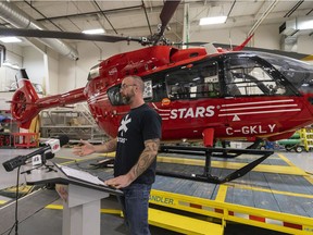 Mike Herbison, a man who was rescued by STARS in 2016, speaks to media and guests in front of an Airbus H145 helicopter at the Mosaic Hangar at STARS Regina on Mar. 16, 2022.