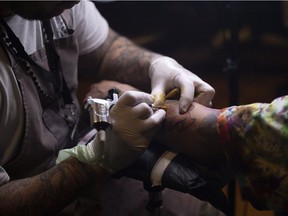 Nolan Malbeuf of The Midnight Oil Tattoo Company tattoo’s Arden Ballantyne during the Pile O Bones tattoo convention at the Turvey Centre on Saturday, March 19, 2022 in Regina.