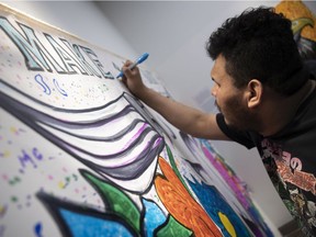 Eric Black draws works on a mural during the Make A Mark art exhibit opening gala at the George Bothwell Branch of the Regina Public Library on Friday, March 25, 2022 in Regina. The exhibit is on display until the end of May.