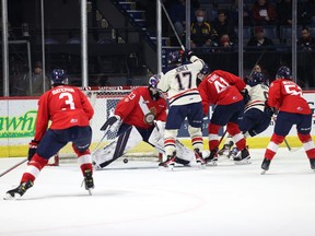 The Lethbridge Hurricanes' Justin Hall (second from right) scores the winning goal in overtime Saturday against Regina Pats netminder Drew Sim. Jett Jones, 17, who scored back-to-back goals after Regina went ahead 4-2, celebrates Hall's game-winner.