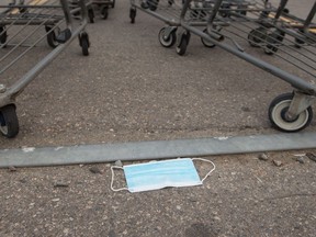 A mask lays discarded near some shopping carts in the parking lot of the Walmart store in Harbour Landing in Regina, Saskatchewan on Sept. 14, 2020. BRANDON HARDER/ Regina Leader-Post