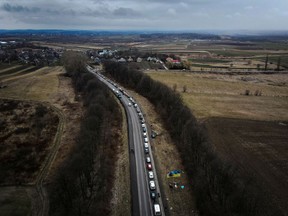 Cars line up on the road to the Shehyni border crossing as people flee to Poland, after Russia launched a massive military operation against Ukraine. Photo taken outside Mostyska, Ukraine, Feb. 27, 2022.