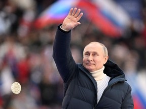 A fashionable Russian President Vladimir Putin waves during a rally marking the eighth anniversary of Russia's annexation of Crimea at the Luzhniki stadium in Moscow on March 18, 2022.