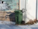 Tempat sampah hijau dari proyek percontohan kompos Kota Regina terlihat di sebuah gang di kawasan North Central di Regina, Saskatchewan pada 18 November 2020.