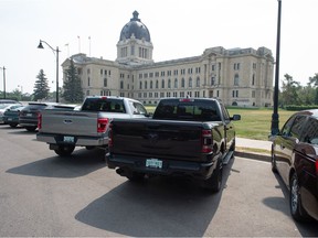 Pickup trucks can be seen at the Saskatchewan Legislative Building in Regina in summer 2021.