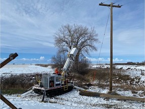 SaskPower crews at work in southwest Saskatchewan following a spring storm that bough heavy snow and howling winds, toppling power poles.