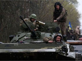 Able-bodied Ukrainian men between the ages of 18 and 60 are not allowed to join millions of women and children as refugees. (Photo: Ukrainian soldiers stand on their armoured personnel carrier (APC) not far from the front-line with Russian troops.)