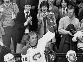 Montreal Canadiens legend Guy Lafleur acknowledges a standing ovation at the Forum on March 4, 1981 after registering his 1,000th NHL point. Standing just behind Lafleur to the left, wearing a dark blazer and tie, is 15-year-old Mario Lemieux.