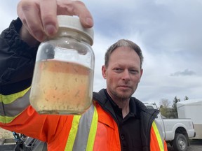 City of Regina pest control supervisor Ryan Johnston holds up a sample of treated water, containing mosquito larvae, near Rainbow Bridge on old Fleet Street on Thursday, May 19, 2022.