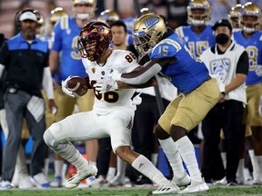 Jordan Genmark Heath, right, of the UCLA Bruins tackles Curtis Hodges of the Arizona State Sun Devils on Oct. 2 in Pasadena, Calif. Genmark Heath was chosen by the Saskatchewan Roughriders with the fifth overall pick of Tuesday's CFL global draft.