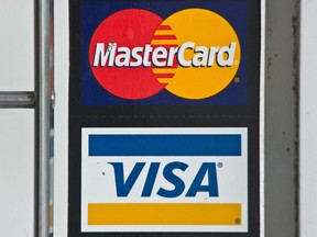 In this file photo taken on March 30, 2012, Visa and MasterCard credit card logos are seen in a store window in Washington, DC.