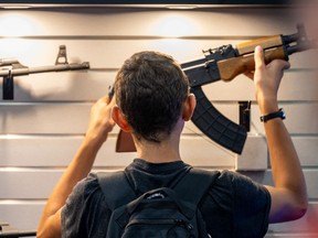 A boy examines a firearm at the George R. Brown Convention Center during the National Rifle Association (NRA) annual convention on May 28, 2022 in Houston, Tex.