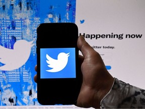 In this file photo illustration taken on April 26, 2022 a phone screen displays the Twitter logo on a Twitter page background, in Washington, DC.