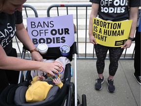 A sign reading "Bans Off Our Bodies" is displayed on the stroller of Lilith Centola, in front of the US Supreme Court in Washington, DC, on May 3, 2022.