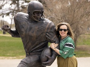 Globe Theatre artistic director Jennifer Brewin, poses with the George Reed statue outside Mosaic Stadium.