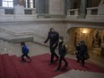 NDP Leader Ryan Meili walks up the main staircase inside the Saskatchewan Legislative Building with his family before question period.