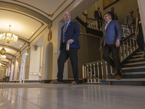 B.C. Premier John Horgan, left, and Premier Scott Moe head towards a media scrum at the Hotel Saskatchewan on Friday.